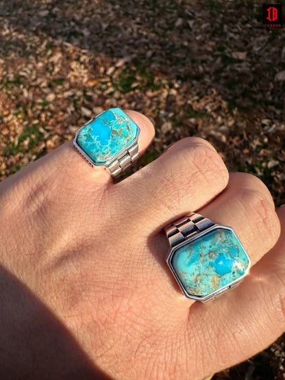 A hand showcasing two rings adorned with Blue  turquoise stones.